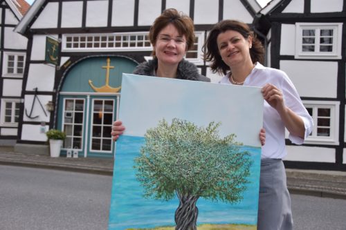 Anker Villa Ausstellung Scharf web Die Künstlerin udn eine Mitarbeiterin der Anker Villa zeigne ein Bild.