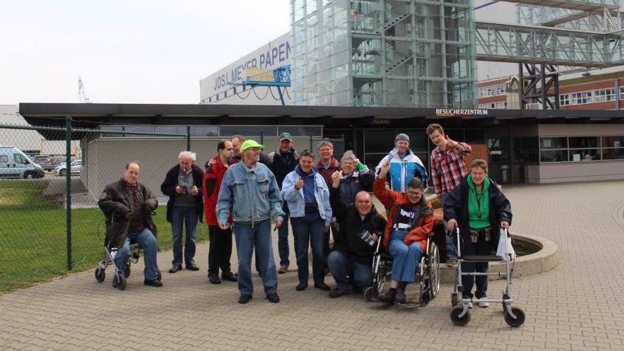 Foto einer Besuchergruppe vor einem großen Gebäude der Meyer Werft